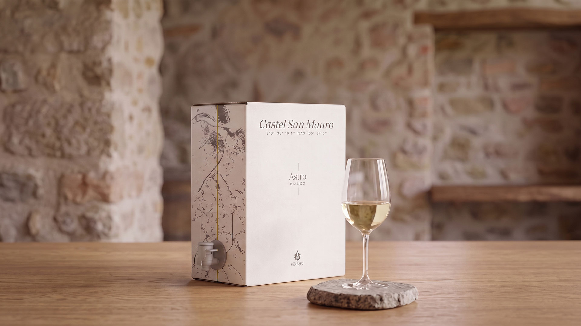 Il bag in box Astro Bianco su un tavolo di legno, con un calice di vino bianco