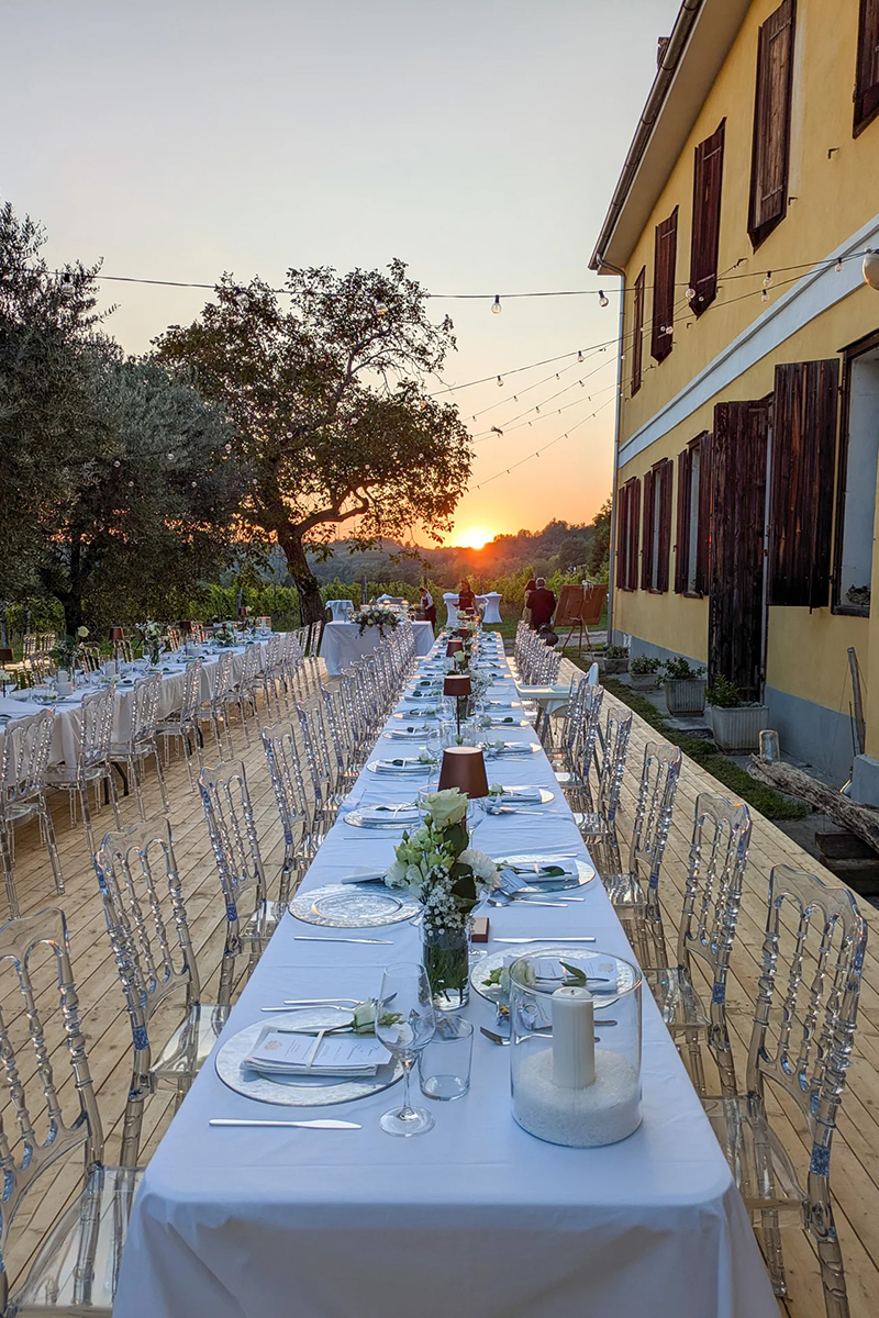 La tavolata lungo la facciata della villa, al tramonto