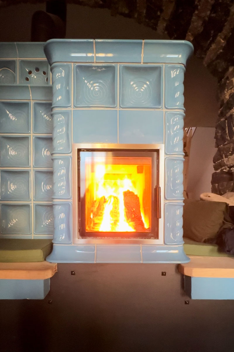 La grande Stube in maiolica azzurra, con il fuoco acceso